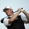 Ernie Els sports blue golf apparel while dismissing Luke Donald