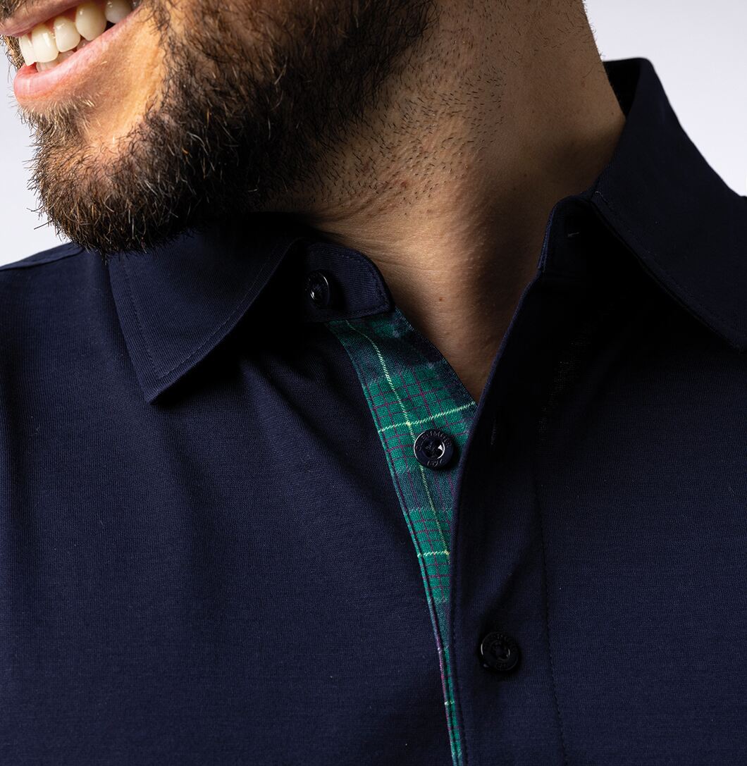 Close up of navy collared golf shirt with tartan placket